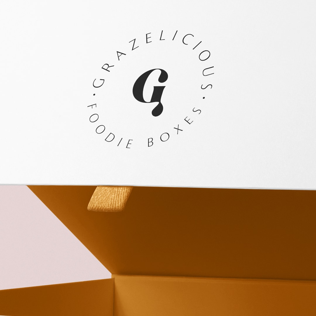Graze Box packaging design logo design on white magnetic box with yellow ribbon